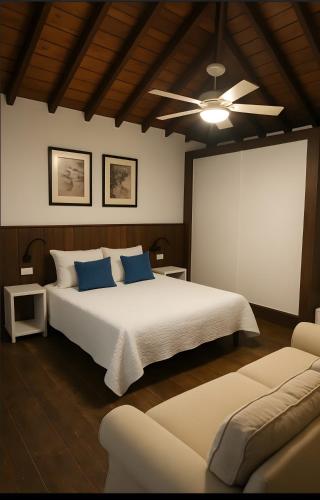 a bedroom with a large white bed with blue pillows at Casa Miranda 3 in Igueste