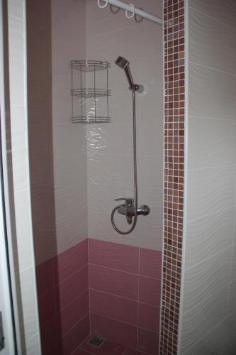 a shower in a bathroom with red and white tile at Апартаменты Step in Sochi