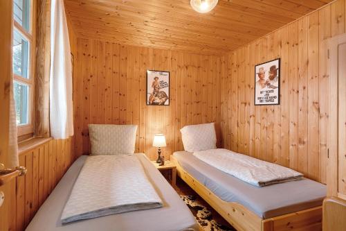 a room with two beds in a wooden cabin at Wooden Western Lodge Tiny Haus in Brekendorf