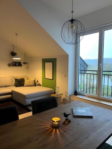 a living room with a table and a bed and a room with a view at moselquartier terlinden- Loft in Perl