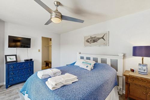 a bedroom with a blue bed with towels on it at Sandy Bottom VROBX in Kitty Hawk