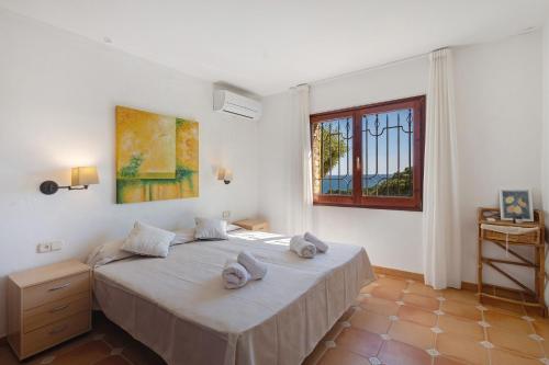 a bedroom with a bed and a window at Roc Blau in Begur