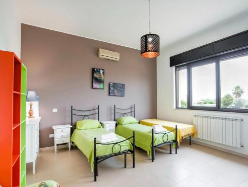 a room with two beds and a table and chairs at Villa Germano con piscina in Solarino