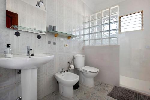 a white bathroom with a toilet and a sink at Jalón de Cameros in Tacoronte