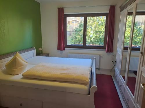 a white bed in a room with two windows at Zweiraum-Ferienwohnung Mitte in Marienberg