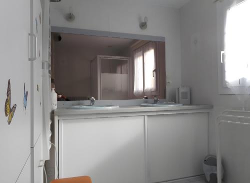 a bathroom with two sinks and a mirror at Chambre De Convenant Hery Bihan in Coatreven