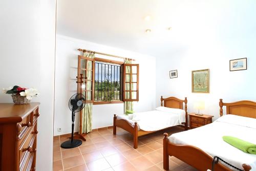 a bedroom with two beds and a window at Villa L´Embat in Pollença