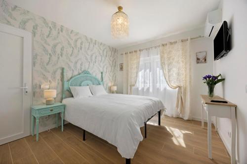 a bedroom with a bed with a blue headboard and a window at Encanto dos Montes in Alvor