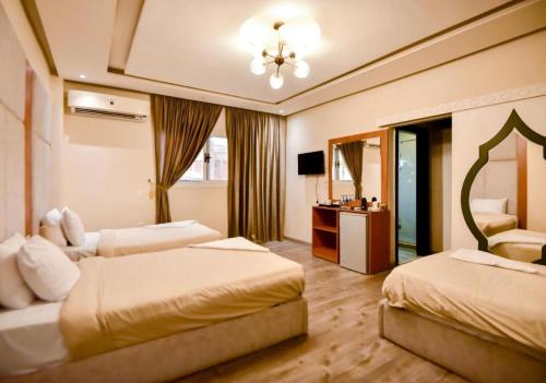 a hotel room with two beds and a television at Solima Pyramids View in Cairo