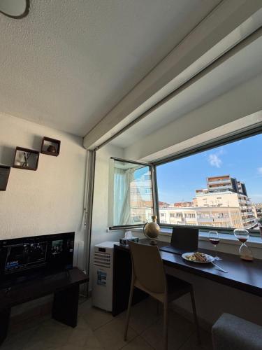 a room with a desk with a view of a city at La nuit Douce in Annemasse