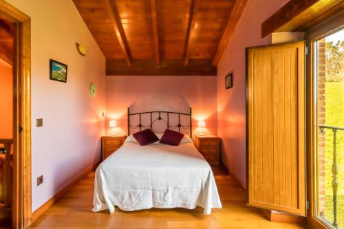 a bedroom with a bed and a large window at Casa Alba in Bárcena de Cicero