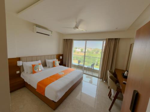 a hotel room with a large bed and a window at Hotel Neem Heritage in Shirdi