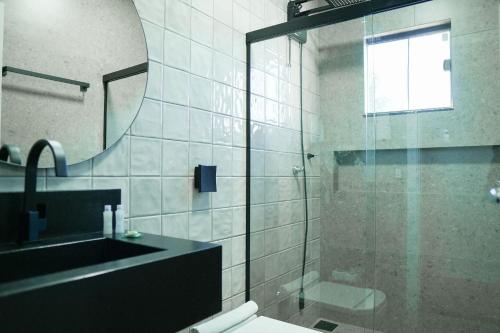a bathroom with a shower and a sink and a mirror at Casa Beverly, com Piscina, 3 Quartos e Churrasqueira in Foz do Iguaçu