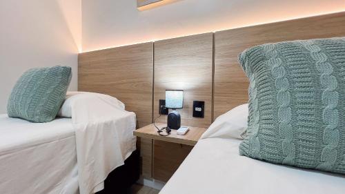 a hotel room with two beds and a head board at Casa Beverly, com Piscina, 3 Quartos e Churrasqueira in Foz do Iguaçu
