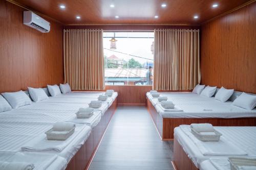 a large room with four beds and a window at Savor Hostel-Motorbike Rental-Tour in Làng Lap