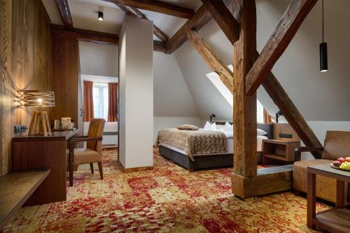 a bedroom with a bed and a desk in a room at Hotel Singer in Ludvíkov