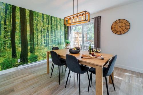 a dining room with a table and chairs and a large window at Le Taiga - Pool Table Nature Pet Friendly in Pont-Rouge