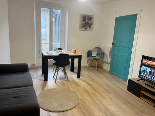 a living room with a table and a tv at Bleu Mandarou in Millau