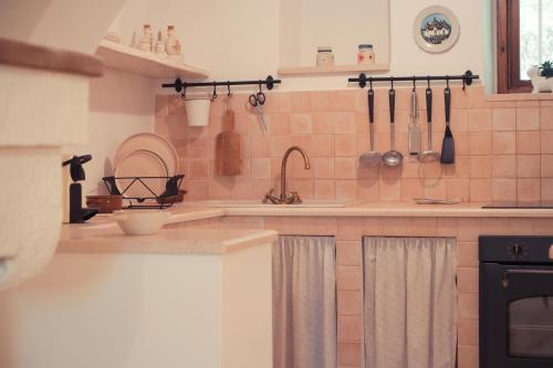 a kitchen with a sink and utensils on the wall at Villa Trullo Vecchia Aia in Alberobello