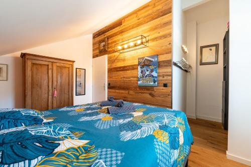 a bedroom with a blue bed with a wooden wall at Maison neuve proche lac d'Annecy in Saint-Jorioz