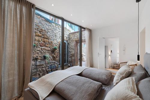 a bedroom with two beds in front of a stone wall at Das Alte Pfarrhaus - Scheune in Gleisweiler