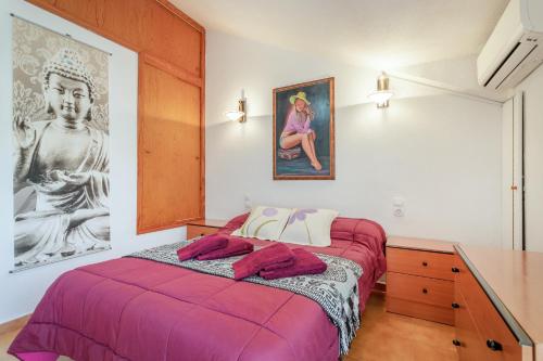 a bedroom with a bed and a painting on the wall at Playa Arenales del Sol in Arenales del Sol