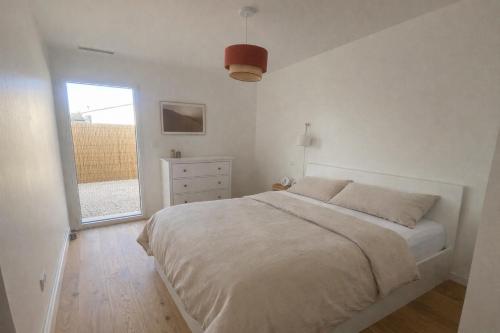 a white bedroom with a bed and a window at L'échappée in Viols-le-Fort