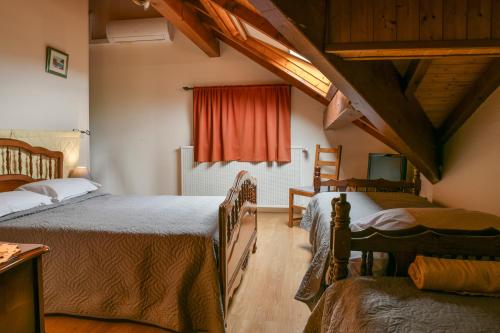 a bedroom with two beds and a red curtain at L'orée du bois in Yenne