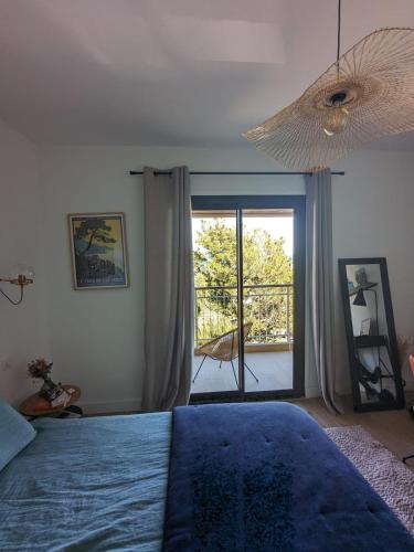 a bedroom with a blue bed and a large window at U Flenu sea view in San-Martino-di-Lota