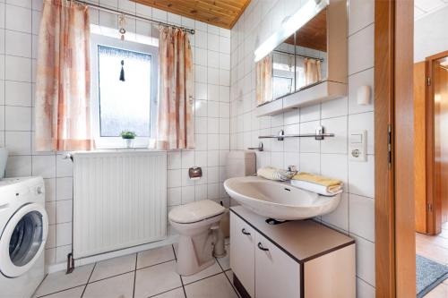a bathroom with a sink and a washing machine at Monteurwohnung in Schwanewede