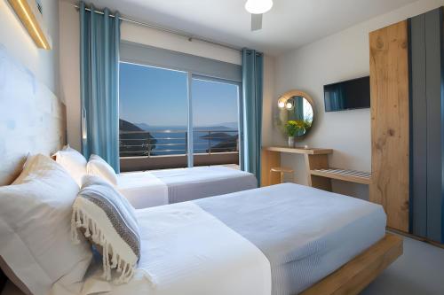 a bedroom with two beds and a large window at Modern Country Villa in Lefkada