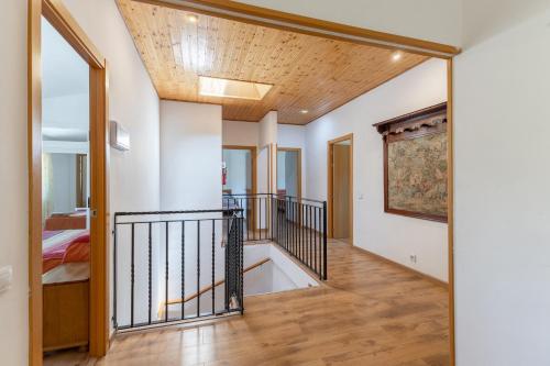 a hallway with white walls and a wooden ceiling at La Nave de Gredos in Burgohondo