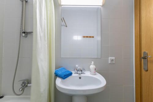 a bathroom with a white sink and a shower at La Nave de Gredos in Burgohondo