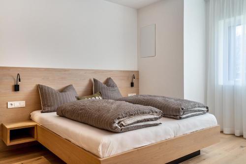 a bedroom with a bed with pillows on it at Mountain Meadows Apt 3 in Valdaora