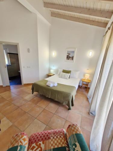 a bedroom with a bed and chairs in a room at Paraiso da Serva - Courela da Serva in Odemira