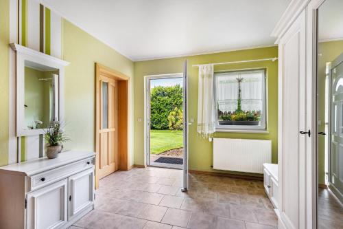 a bathroom with green walls and a door with a window at Ferienhaus Jasmin in Neuruppin
