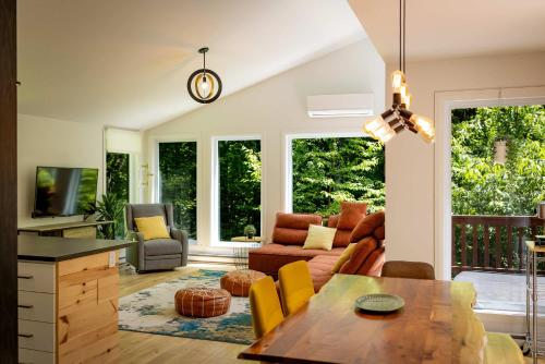 a living room with a couch and a table at Chalet Victoria - Private Spa & Nature in Pont-Rouge