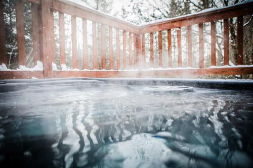 a pool of water in front of a wooden fence at Chalet Victoria - Private Spa & Nature in Pont-Rouge