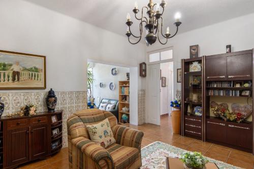 a living room with a couch and a chandelier at Vivenda Barros in Sangalhos