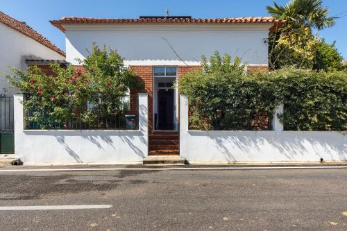 a white house with a door on a street at Vivenda Barros in Sangalhos