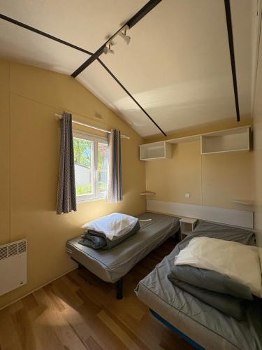 a room with two beds and a window at Camping Arquebuse in Auxonne