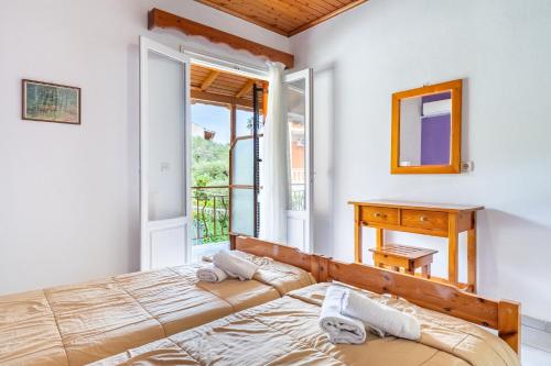 a bedroom with a bed and a desk and a window at Maltas studios in Corfu