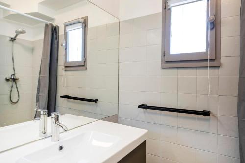 a white bathroom with a sink and a mirror at Evasion Atlantique, accès plage in Capbreton