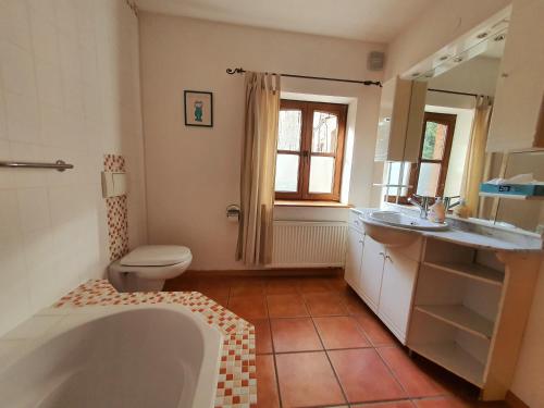a bathroom with a tub and a toilet and a sink at Schöne Wohnung Landhaus-Flair in Aachen