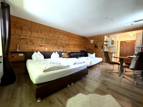 a bedroom with two beds and a table and chairs at Zirbenstüberl - Chiemgau Karte in Inzell