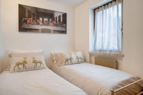 two beds sitting next to each other in a bedroom at Appartamento Eva in Folgaria