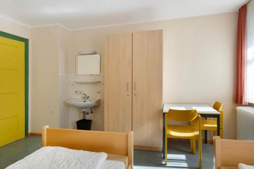 a bedroom with a bed and a desk and a sink at Ferienheim Eisenbach in Eisenbach