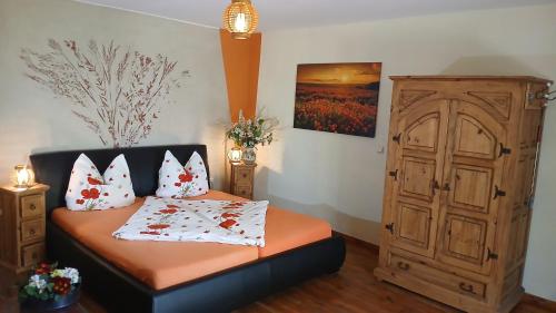 a bedroom with a bed and a wooden cabinet at Ferienwohnung Sophienhof in Loitz