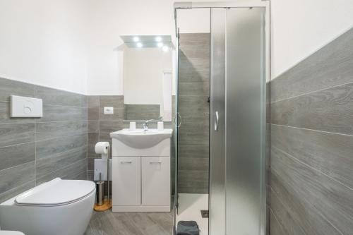 a bathroom with a toilet and a sink and a shower at Casa Claudia in Assemini