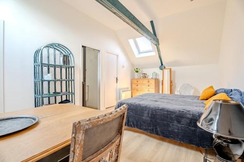 ein Schlafzimmer mit einem Bett und einem Holztisch und einem Schreibtisch in der Unterkunft Les mesliers in Sens-de-Bretagne